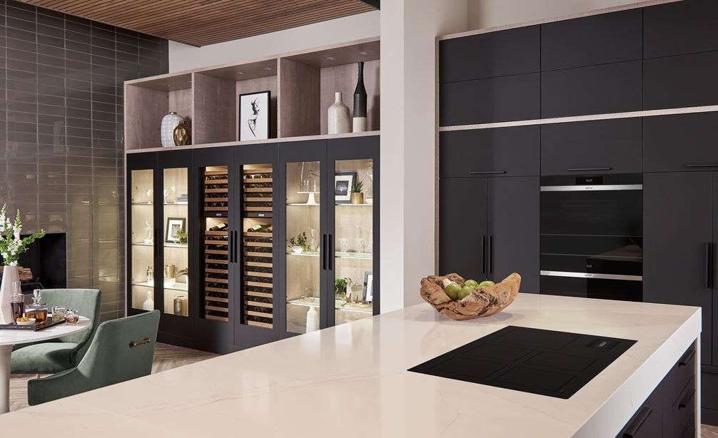 Surface de cuisson à induction Wolf 36 po de style contemporain (CI36560C/B) présentée dans un design de cuisine ouverte avec un grand îlot de cuisine blanc et des armoires de cuisine noires.
