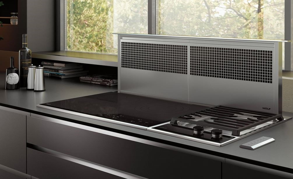 La ventilation à aspiration descendante Wolf 45 po (DD45) constitue le point d’orgue de ce design de cuisine ultra-moderne équipée d’un comptoir et d’armoires au fini lisse.
