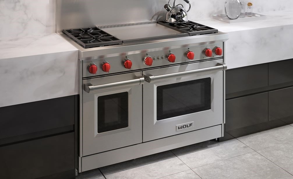 La cuisinière à gaz Wolf 48 po à 4 brûleurs avec plaque à frire double infrarouge (GR484DG) présentée dans un design de cuisine moderne épurée et minimaliste