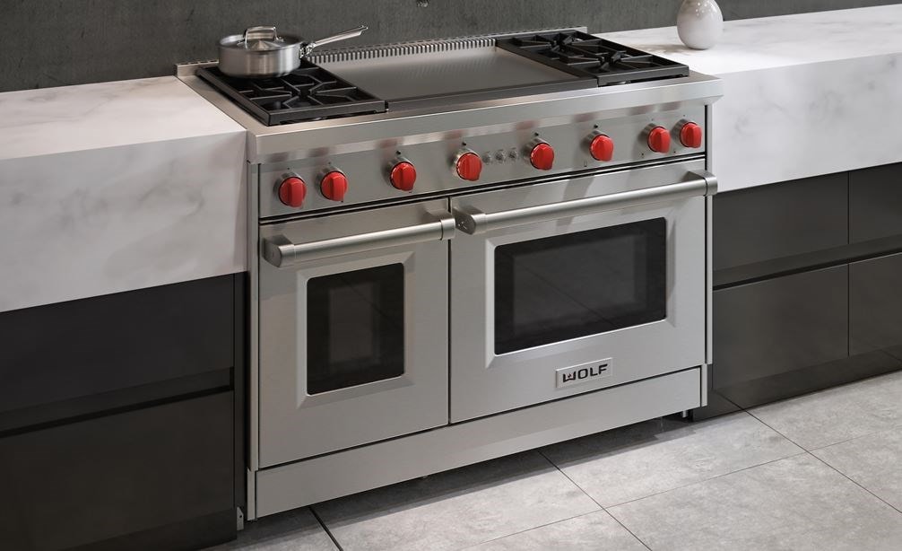 La cuisinière à gaz Wolf 48 po à 4 brûleurs avec plaque à frire double infrarouge (GR484DG) présentée dans un design de cuisine moderne et contemporain
