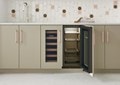 Interior view of Sub-Zero 15" Designer Undercounter Beverage Center - Panel Ready (DEU2450BG) shown in a row of tan custom cabinets
