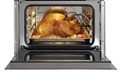 Interior view of an open Wolf 24&quot; E Series Transitional Convection Steam Oven (CSO2450TE/S/T) displaying a perfectly cooked chicken with a probe in it