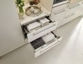 A 30" Warming Drawer (WWD3050) from Wolf Appliances in bathroom with robes and towels inside.