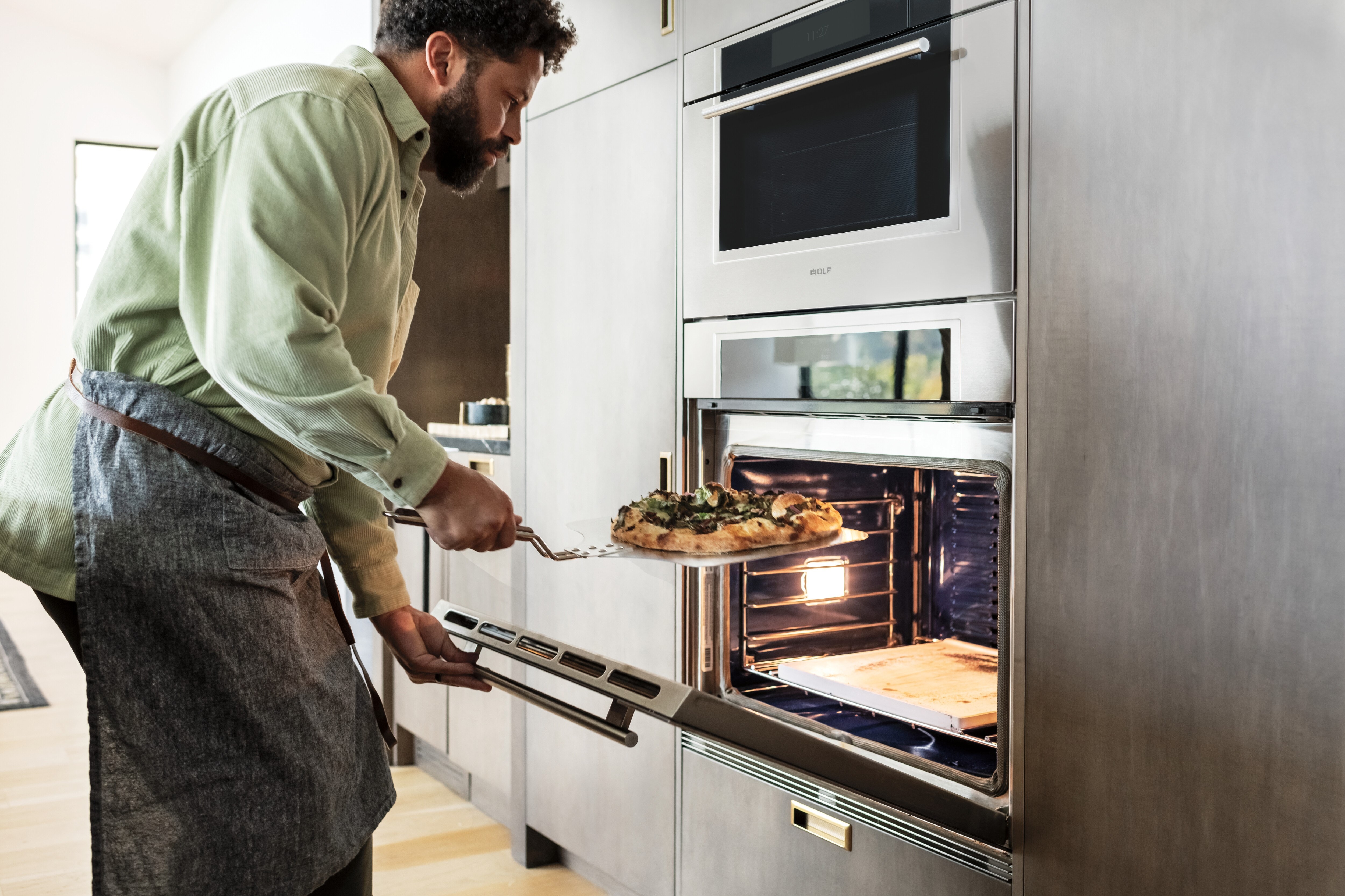 Le four à convection-vapeur Wolf de 30 po et le four simple transitionnel de la série M sont présentés dans une armoire de cuisine personnalisée