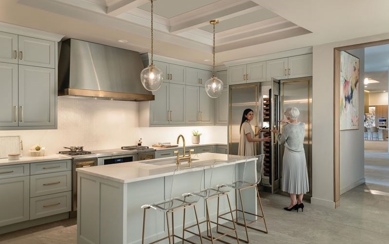 Customers exploring Wolf Ovens during an in person product demonstration at a local Sub-Zero, Wolf, and Cove Kitchen Appliances Showroom