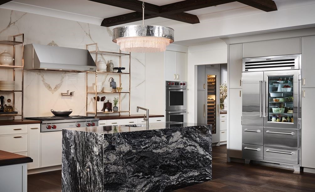 Sub-Zero 48 inch Pro Glass Door Refrigerator Freezer displayed in a large luxury rutic kitchen design featuring warm wood tone countertops and flooring