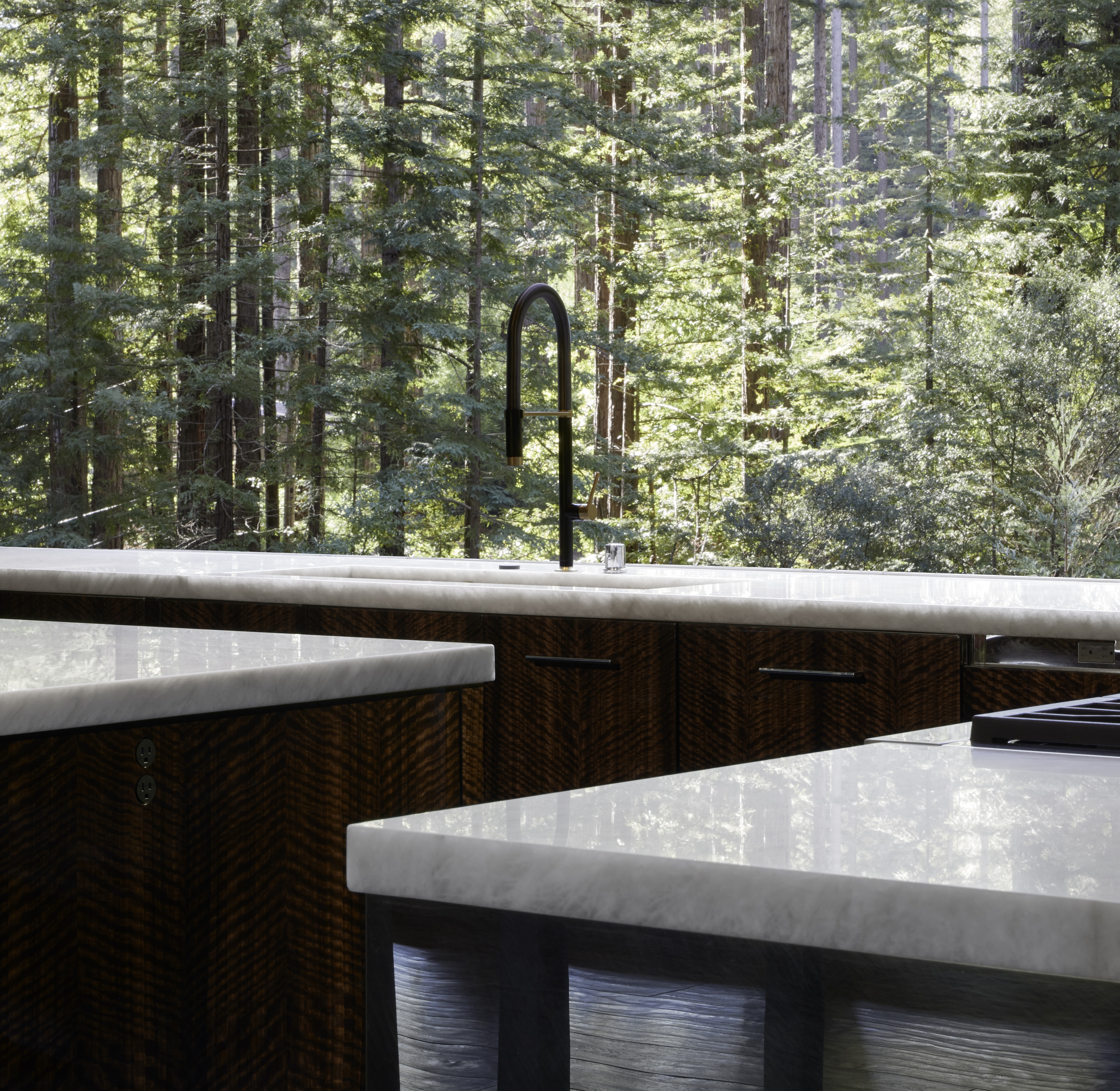 Sub-Zero Wine Storage blends perfectly with the dark hardwood brown floors, bright white walls, and stainless steel accents of this majestic Redwoods setting.