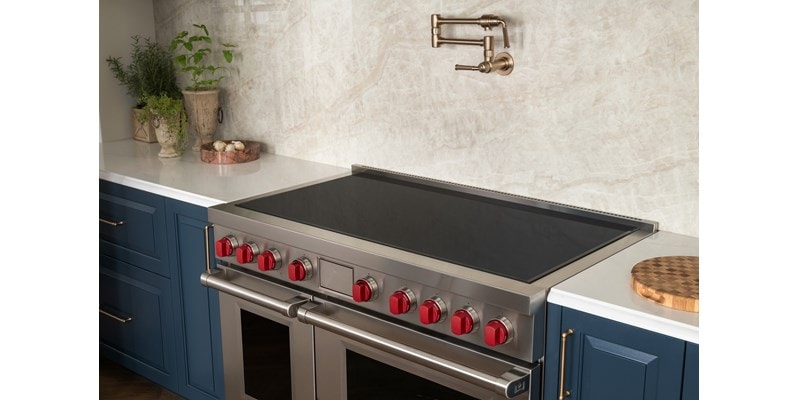 Wolf 36-inch Contemporary Induction Cooktop (CI36560T) featuring sleek black glass surface installed flush in a modern Mediterranean kitchen design.