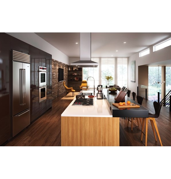 The Wolf 36" Professional Gas Cooktop (CG365P/S) displayed in large center island surrounded by an array of rich earthy tones and textures