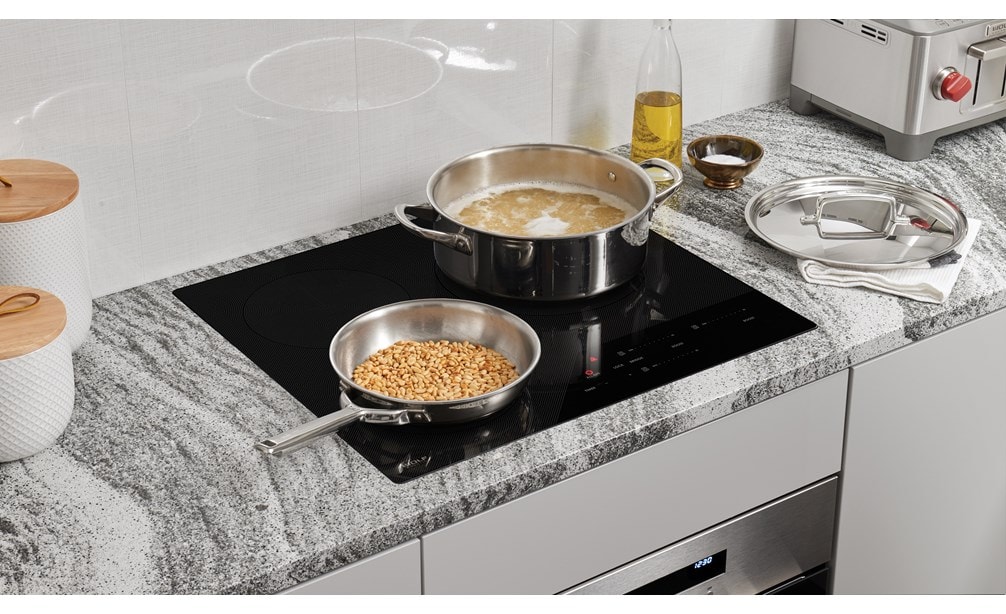 Wolf 24" Contemporary Induction Cooktop (CI243C/B) shown set flush in dark grey black and white swirl granite countertop