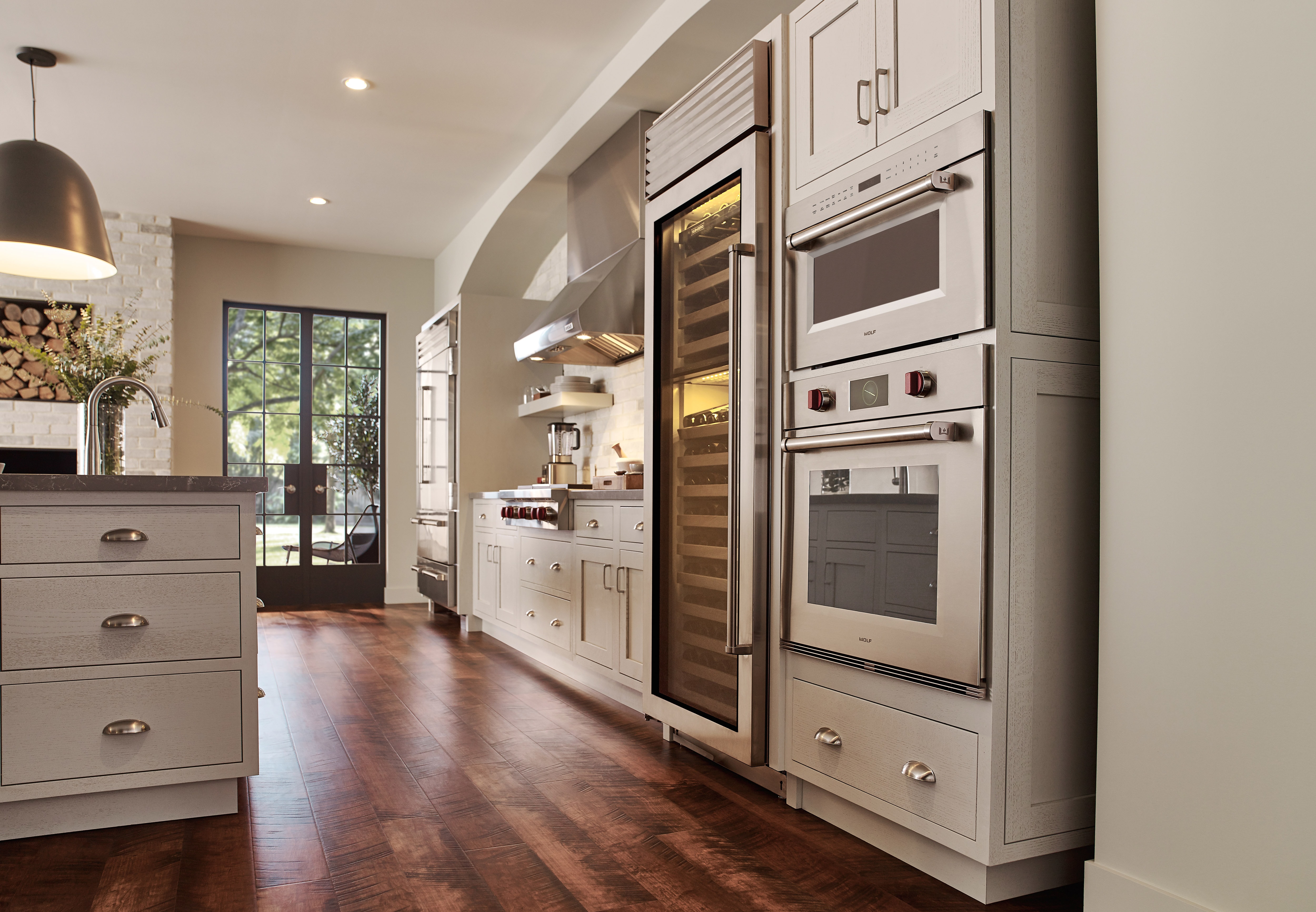 Wolf 30" M series Professional Drop-Down Door Microwave Oven (MDD30PM/S/PH) displayed in a classic medium tone wood floor kitchen design