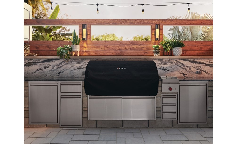 The Wolf 54" Outdoor Gas Grill (OG54) shown blending seamlessly into a rich modern outdoor kitchen design offering pro quality amenities. 