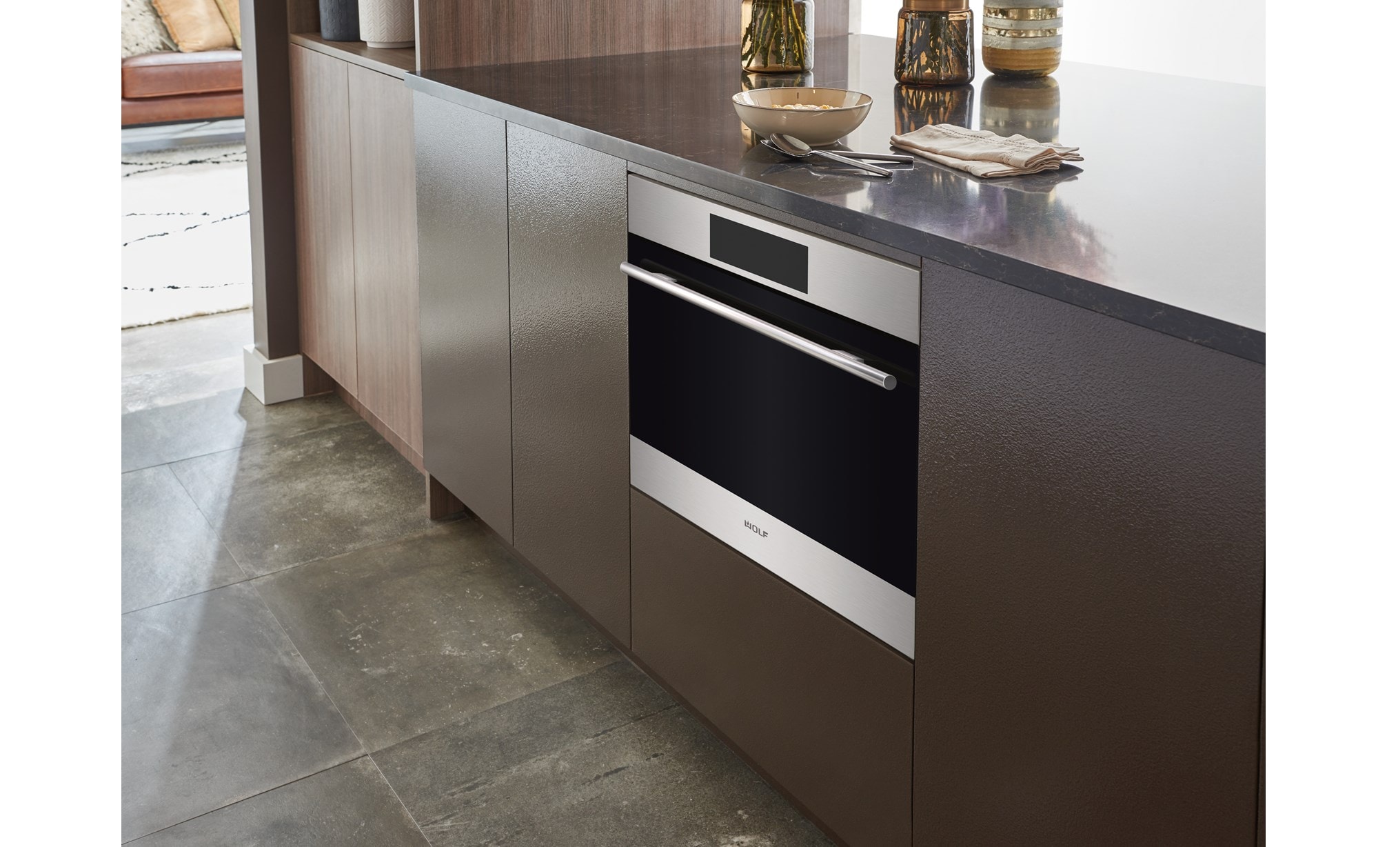 Sub-Zero, Wolf, and Cove's 24" E Series Transitional Speed Oven - SPO24TE/S/TH inside a cabinet with brown panels