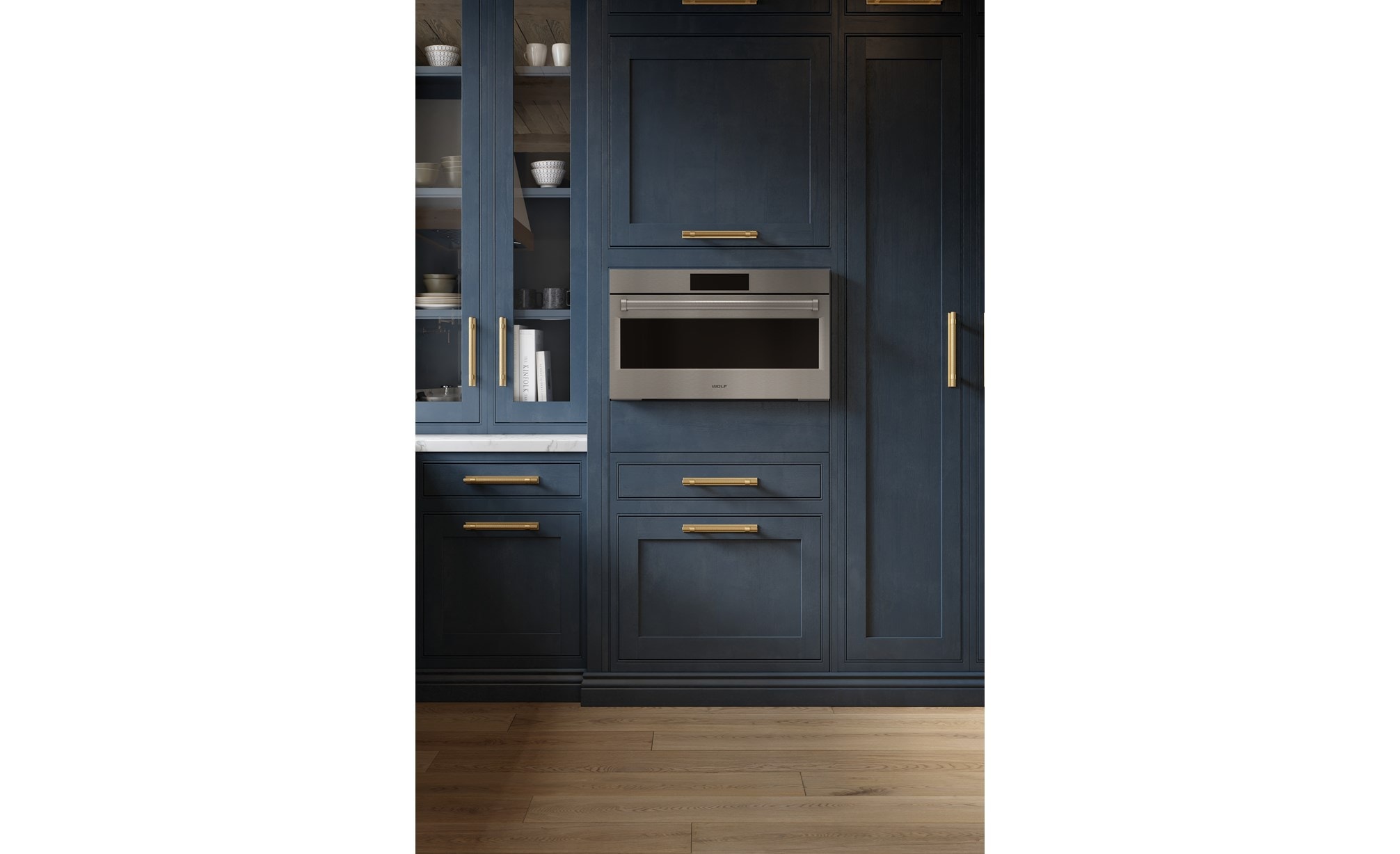 A close-up look at the Wolf 30" E Series Professional Speed Oven - SPO3050/PE/S/P built-in next to blue cabinetry