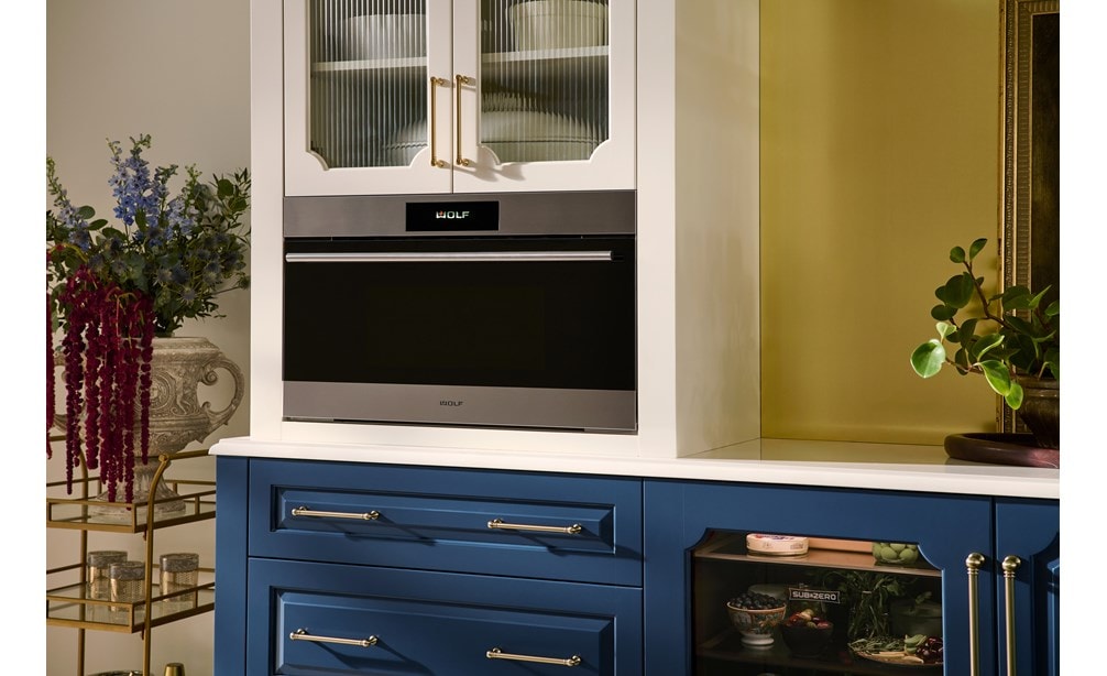 The Wolf 30" E Series Transitional Speed Oven - SPO3050TE/S/T in a modern blue and white kitchen