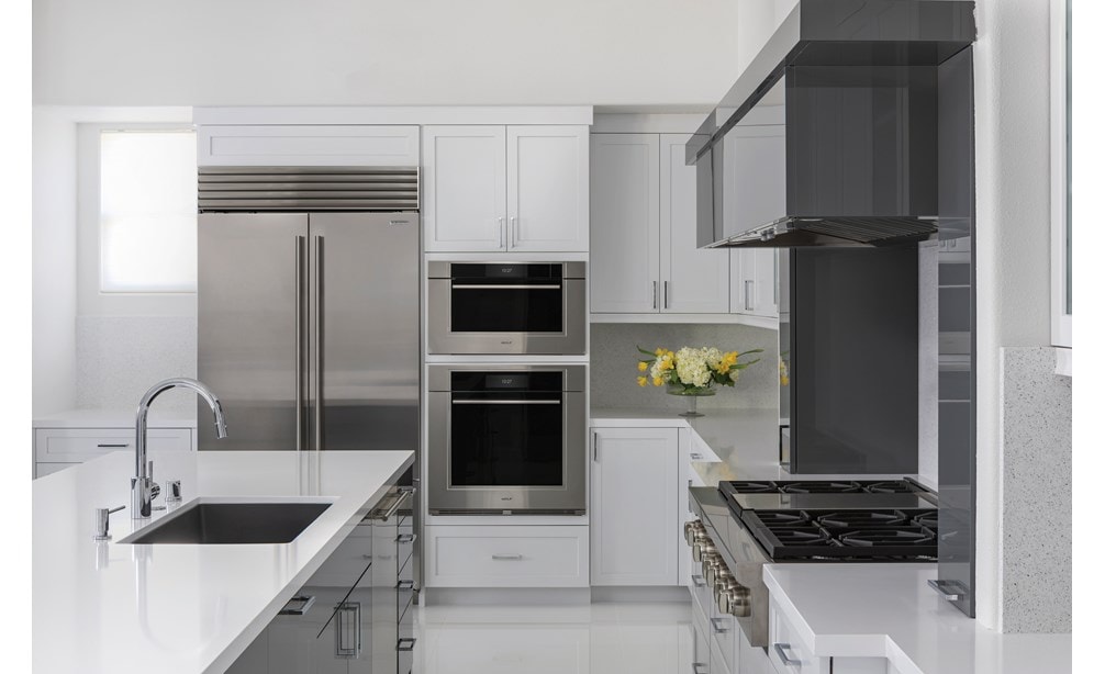 Wolf 30" M Series Transitional Convection Steam Oven (CSO3050TM/S/T) shown in a dimly lit kitchen with glossy white floors and countertops