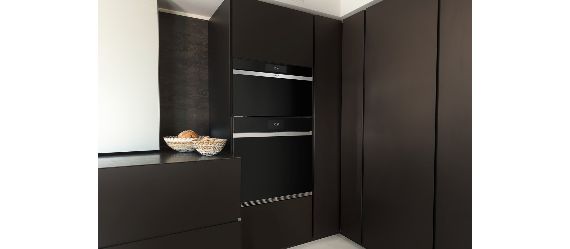 Wolf 30" M Series Contemporary Handleless Steam Oven (CSO3050CM/B) displayed in matte brown custom cabinetry
