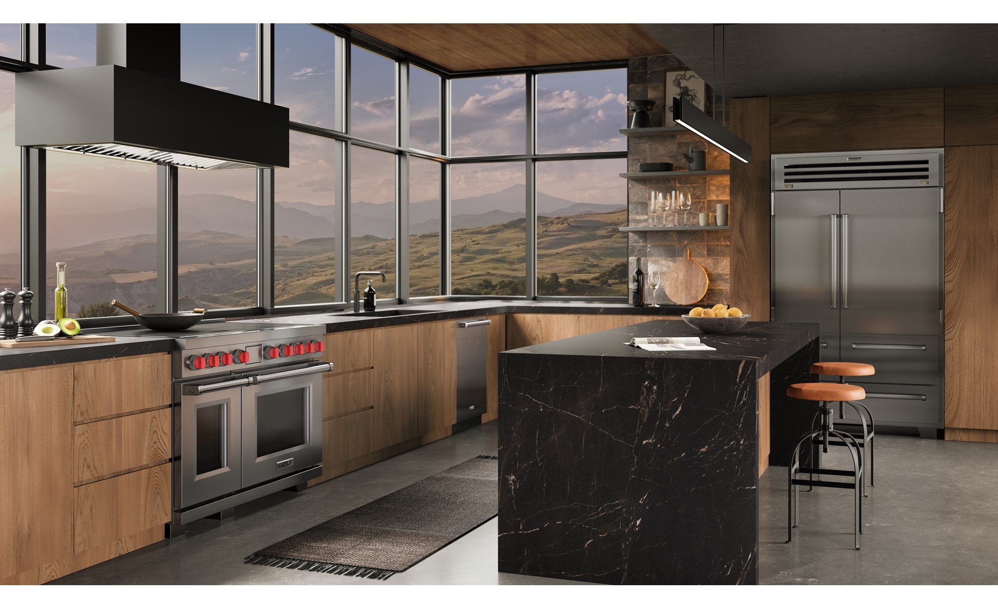Wolf 48 Inch Professional Induction Range with matching stainless steel Sub-Zero 48 Inch PRO Refrigerator Freezer featured in an ambient  industrial kitchen design with a wall of windows overlooking an expansive mountain range.
