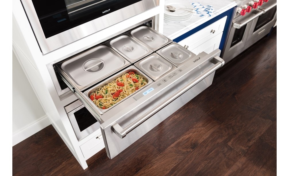 The Wolf 30" Warming Drawer (WD30) displaying it's capacity for holding several dishes while looking great with dark wood floors