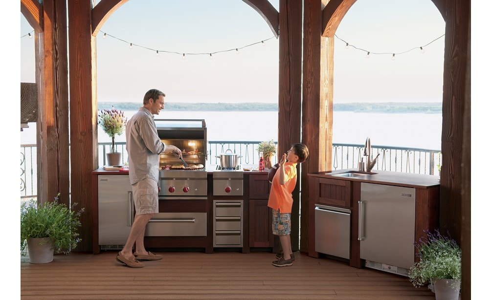 The Wolf 30" Outdoor Warming Drawer (WWD30O) shown in a gourmet outdoor cooking area featuring best-in-class Wolf cooking appliances