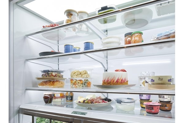 Sub-Zero Classic Series Full Size Refrigerator with propped 48 inch French Door displaying four levels of gleaming fresh food shelving.