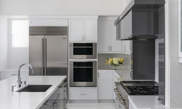 Clean, minimalist kitchen design featuring Sub-Zero Classic Series Refrigerator, Cove Dishwasher, Wolf M Series Oven, Sealed Burner Rangetop and Wolf Speed Oven