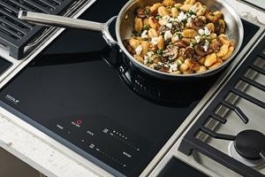 Wolf 15&quot; transitional induction cooktop module (CI152TFS) paired with a 15&quot; transitional grill module (GM15TFS) and 15&quot; transitional gas cooktop module (CE152TFS)
