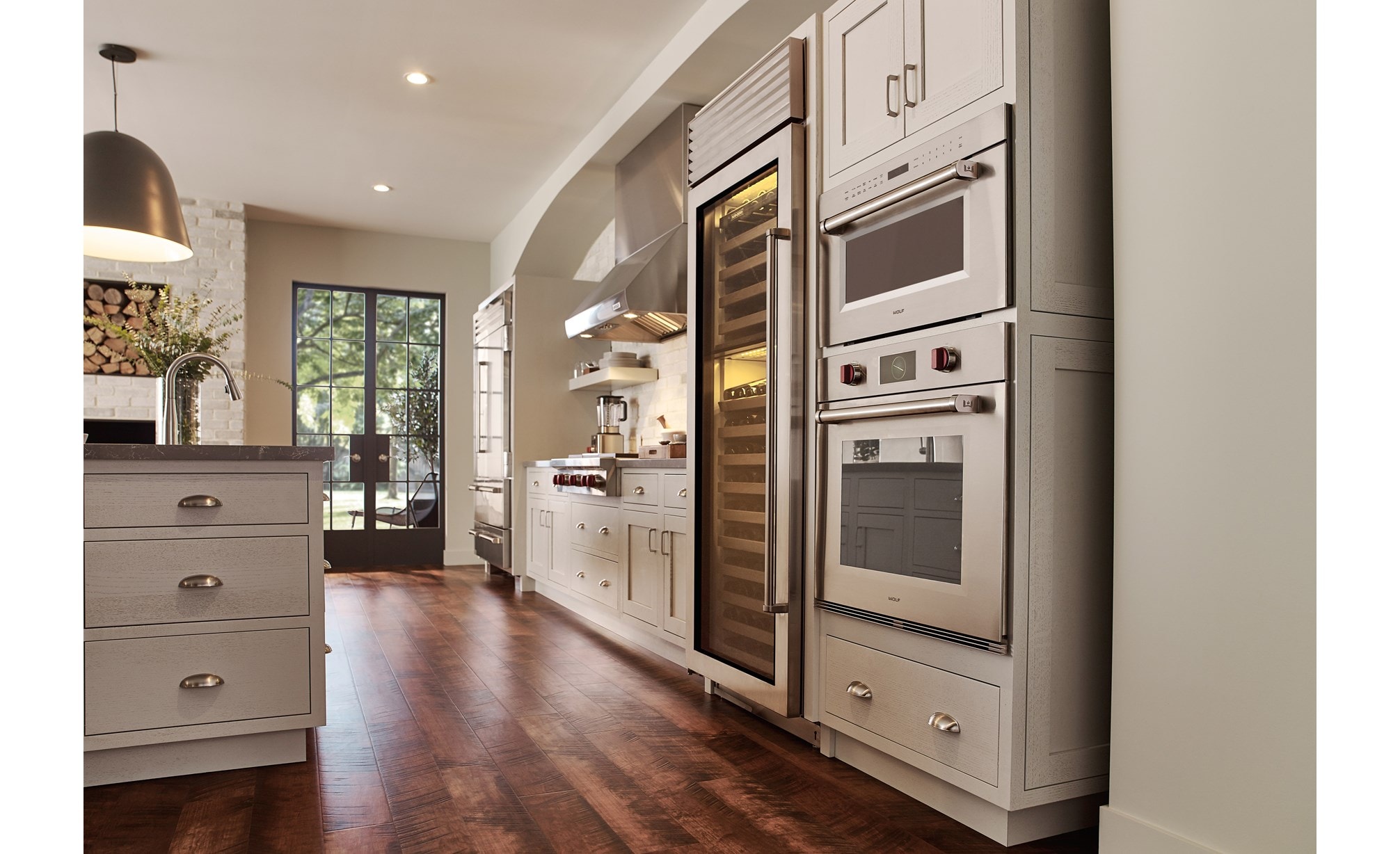 Wolf 30" M series Professional Drop-Down Door Microwave Oven (MDD30PM/S/PH) displayed in a classic medium tone wood floor kitchen design