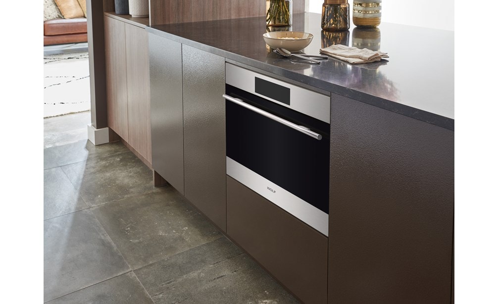 Sub-Zero, Wolf, and Cove's 24" E Series Transitional Speed Oven - SPO24TE/S/TH inside a cabinet with brown panels