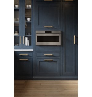 A close-up look at the Wolf 30" E Series Professional Speed Oven - SPO3050/PE/S/P built-in next to blue cabinetry