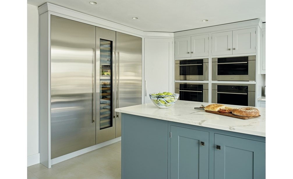 The Wolf 30" M Series Transitional Speed Oven - SPO3050TM/S/T next to a Wolf Convection Steam Oven in a blue kitchen