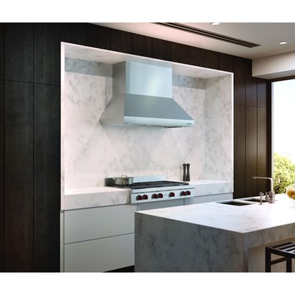 The Wolf 54" Pro Wall Chimney Hood (PWC542418) shown here framed expertly in a rich marble backsplash is the crown jewel of any kitchen 