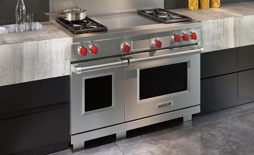 Wolf 48&quot; Dual Fuel Range 4 Burner French Top (DF484F) shown with concrete and minimalist kitchen cabinets in an ultra-modern kitchen