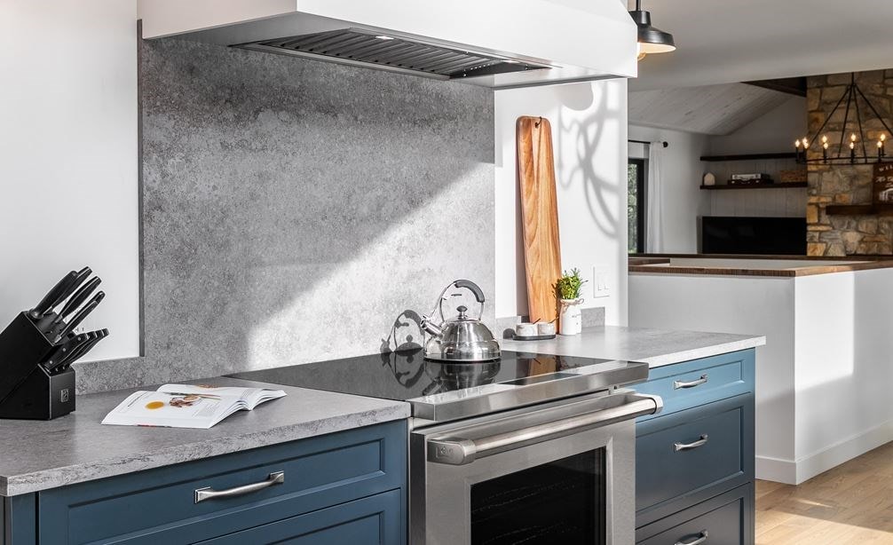 Wolf 30" Professional Induction Range (IR30450/S/P) with a white Wolf Wall Hood featured in navy blue cabinetry.