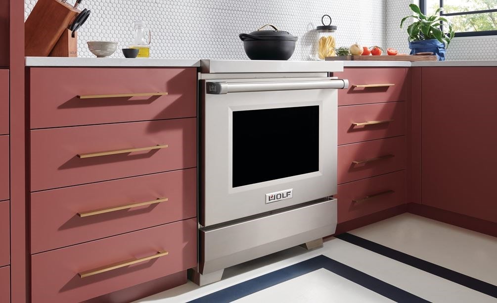 Wolf 30" Professional Induction Range (IR30450/S/P) featured in salmon cabinetry kitchen with a matte black covered pot on its surface.