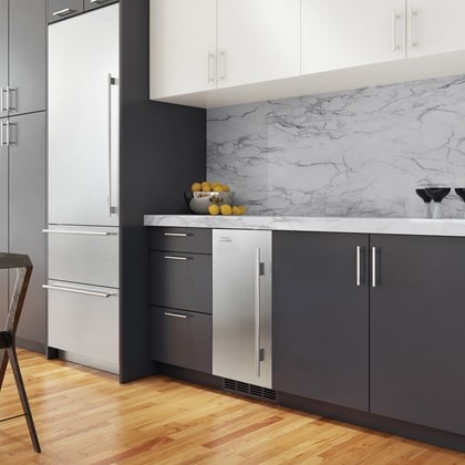 La machine à glaçons Sub-Zero 15 po prête à l'installation d'un panneau (UC-15I) se fond harmonieusement dans des armoires lisses aux tons foncés pour créer un design élégant.