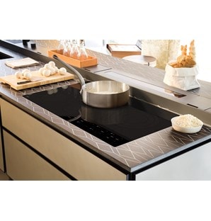Surface de cuisson électrique Wolf 36 po de style contemporain (CE365C/B) encastrée dans une cuisine luxueuse avec des plans de travail design et des armoires sans joints