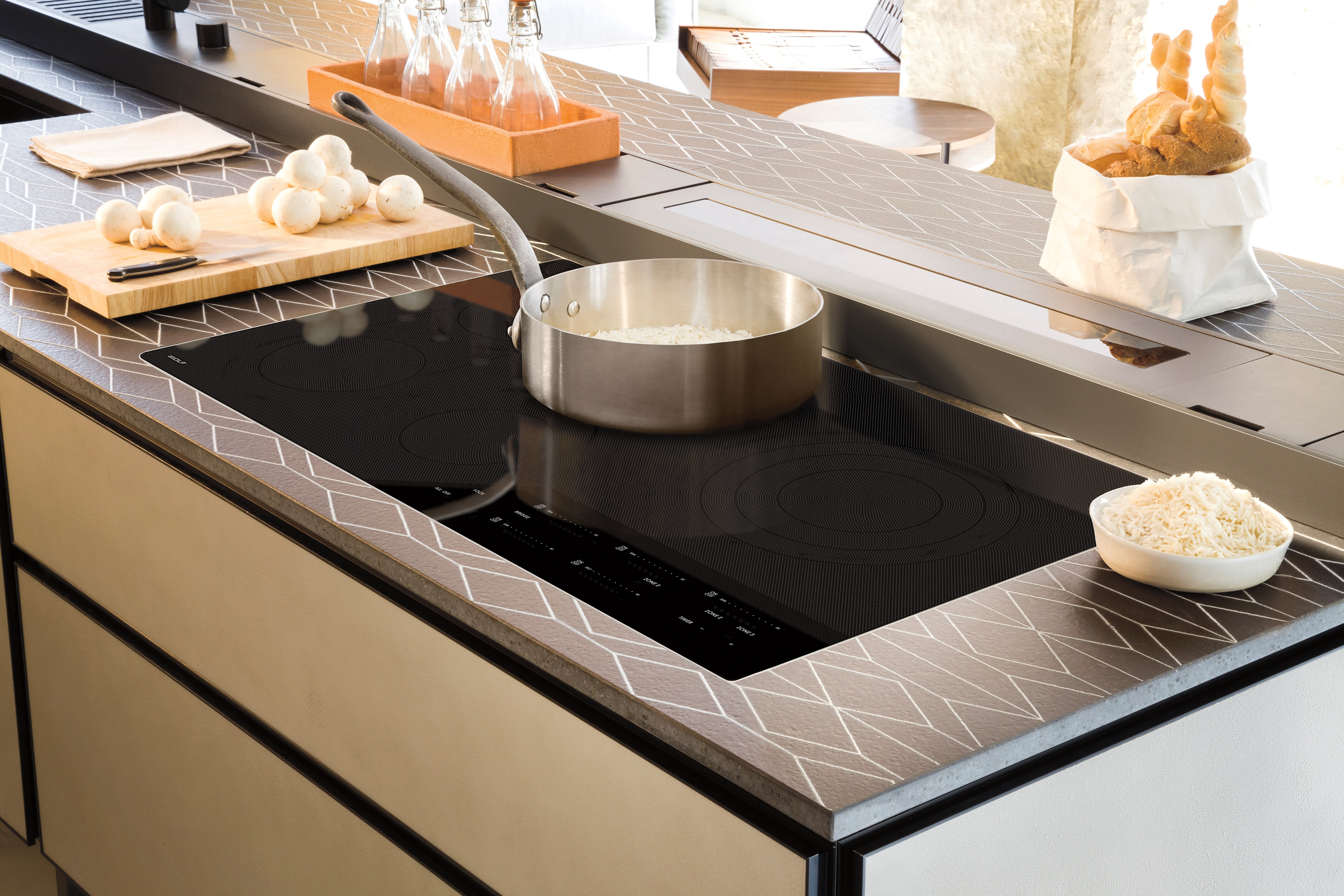 Surface de cuisson électrique Wolf 36 po de style contemporain (CE365C/B) encastrée dans une cuisine luxueuse avec des plans de travail design et des armoires sans joints