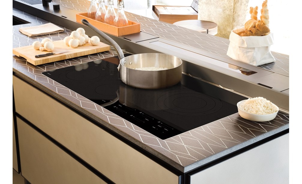 Surface de cuisson électrique Wolf 36 po de style contemporain (CE365C/B) encastrée dans une cuisine luxueuse avec des plans de travail design et des armoires sans joints