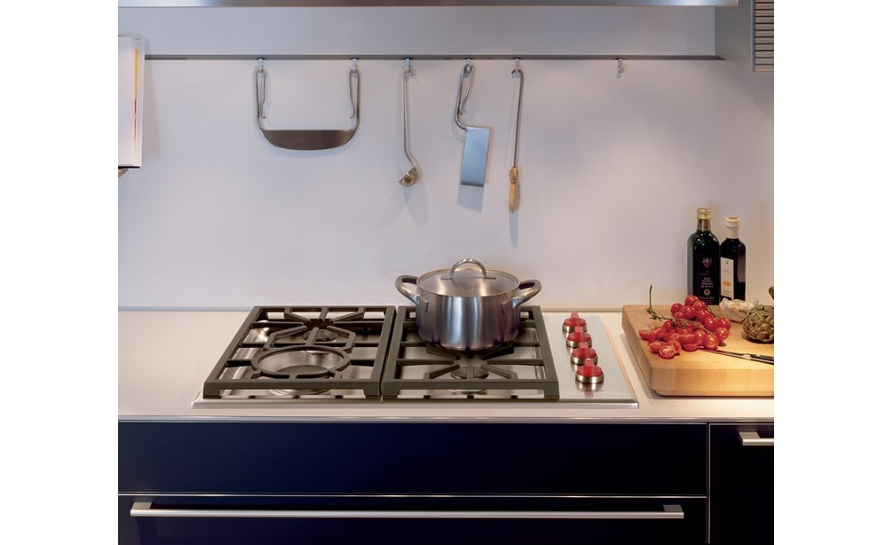 La surface de cuisson à gaz Wolf 30 po de style professionnel à 4 brûleurs (CG304P/S) est présentée avec des boutons rouges caractéristiques et un porte-ustensiles en acier inoxydable