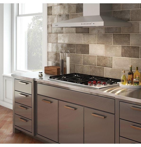 La surface de cuisson au gaz Wolf 36 po de style professionnel (CG365P/S) et le capot mural de surface de cuisson de 36 po en acier inoxydable (VW36S) sont présentés dans un design de cuisine élégant