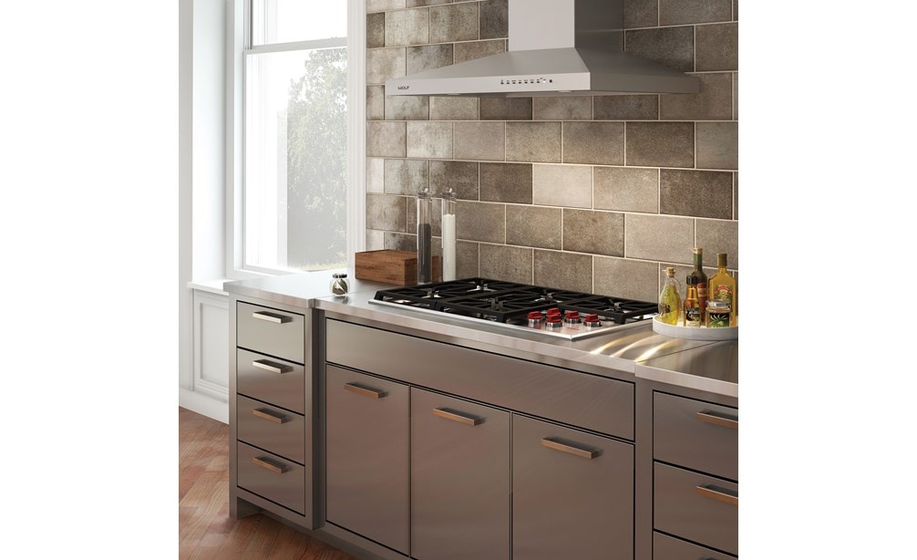 La surface de cuisson au gaz Wolf 36 po de style professionnel (CG365P/S) et le capot mural de surface de cuisson de 36 po en acier inoxydable (VW36S) sont présentés dans un design de cuisine élégant