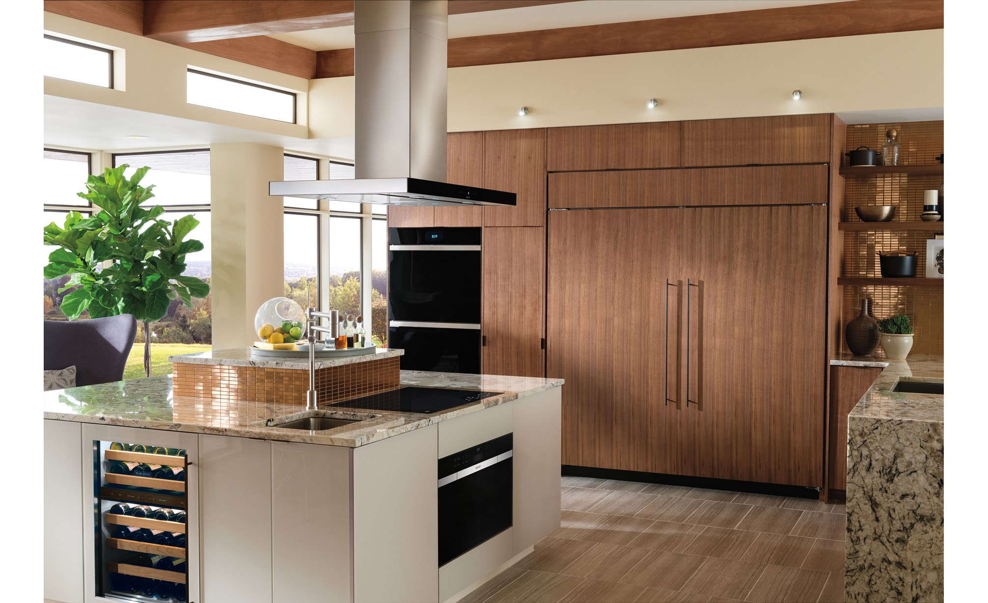 Surface de cuisson à induction Wolf 30 po de style contemporain (CI304C/B) présentée dans un grand îlot de cuisine en marbre avec hotte pour îlot de surface de cuisson Wolf de 42 po (VI42B)