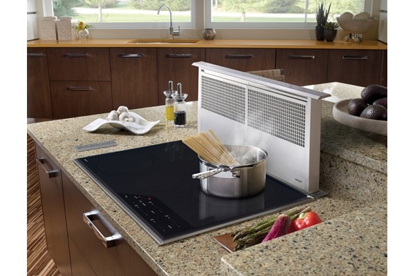 Surface de cuisson à induction Wolf 30 po de style transitionnel (CI304T/S) jumelée à une ventilation à tirage descendant de 30 po (DD30) dans des comptoirs en granit riche