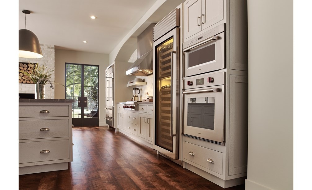 Four à micro-ondes Wolf 30 po série M à porte s'ouvrant vers le bas de style transitionnel (MDD30TM/S/PH) présenté dans une cuisine classique à plancher de bois de tonalité moyenne