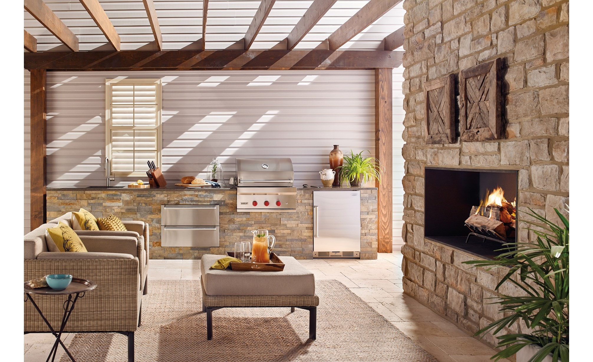 Le gril à gaz d'extérieur Wolf de 30 po (OG30) est présenté avec un tiroir chauffe-plats d'extérieur Wolf de 30 po (WWD30O) dans un espace de cuisine extérieure luxueux.