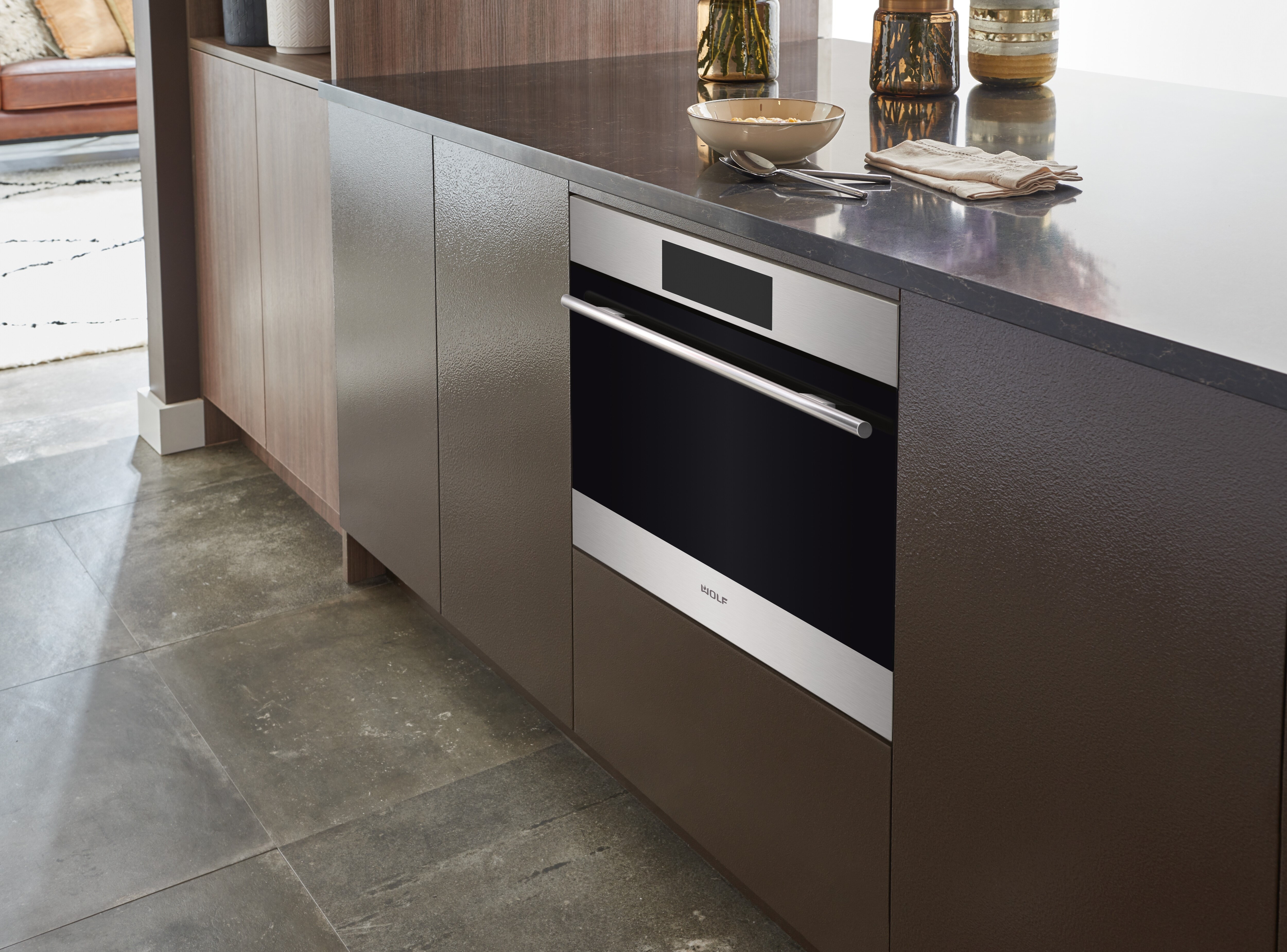 Sub-Zero, Wolf, and Cove's 24" E Series Transitional Speed Oven - SPO24TE/S/TH inside a cabinet with brown panels
