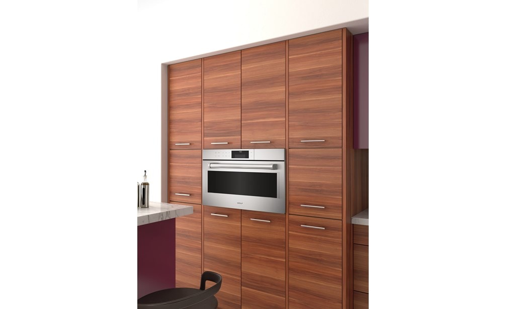 Le four à convection-vapeur de style professionnel de la série E de 30 po de Wolf (CSO30PE/S/PH) est présenté surélevé et encadré dans un style d'armoire sophistiqué 