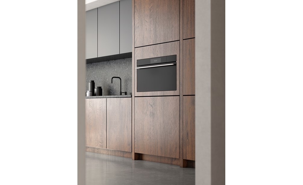 Four à convection-vapeur de style contemporain de Wolf Série M 30 po (CSO3050CM/B/T) exposé à côté d'armoires en bois teinté montrées à travers une porte