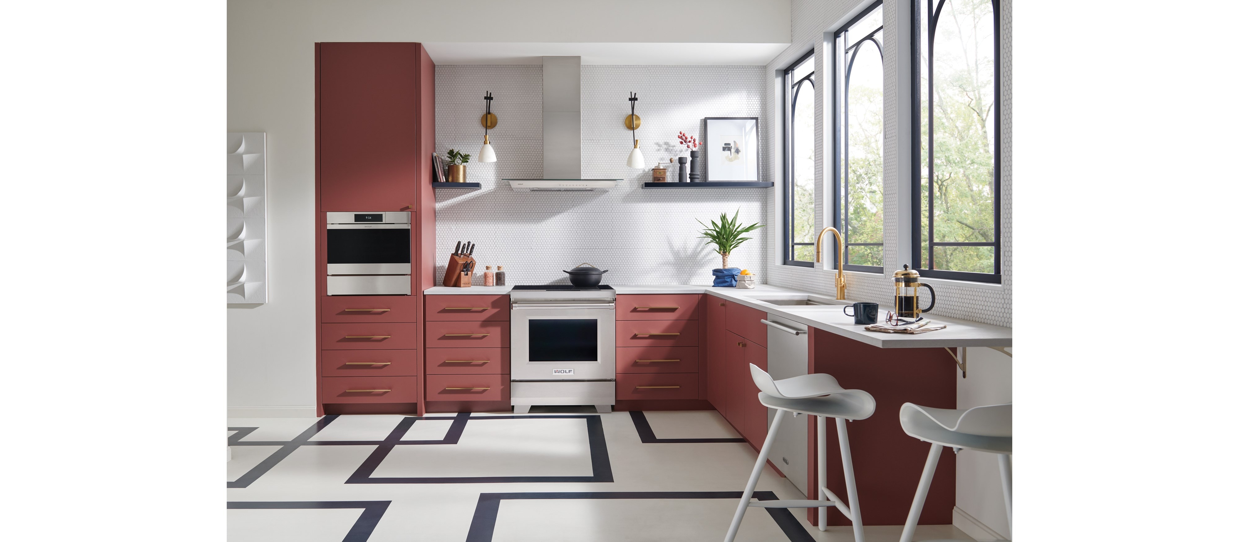 Cuisinière à induction Wolf 30/34 de style professionnel (IR30450/S/P) présentée dans la cuisine à armoires saumon avec revêtement de sol géométrique.